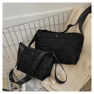 Close-up of black quilted nylon dumpling bag set with adjustable straps in a shopping scene