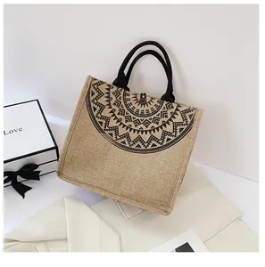 Detalle de bolsa de yute con diseño de mandala negro y asas tubulares de estilo retro