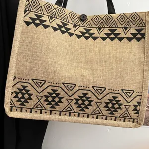 Detail view of ethnic jute tote bag featuring tribal patterns and black button closure