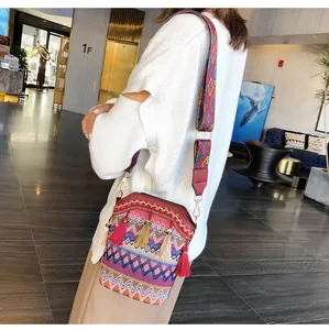 Borsa a secchiello in stile etnico con motivi colorati intrecciati e dettagli di nappe