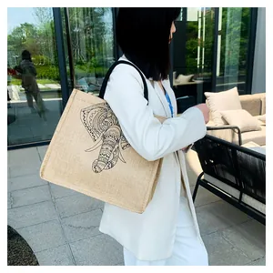Lifestyle view of large linen tote bag with elephant print on a model in outdoor setting
