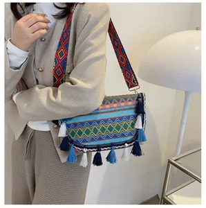 Detail of ethnic embroidery bag showing colorful geometric patterns and decorative tassels