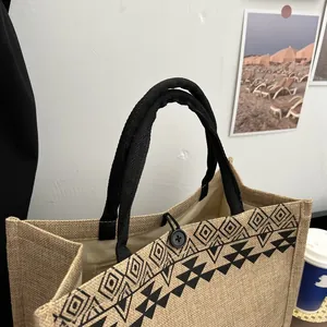 Detail of jute tote bag showing ethnic geometric print and black cotton rope handle