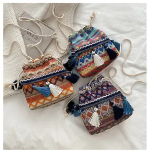 Détails de sacs seaux tissés à cordon avec motifs géométriques et pompons bohèmes