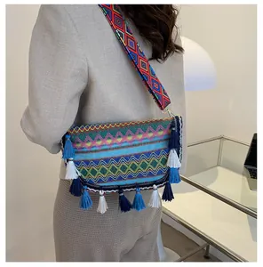 Close-up of bohemian woven crossbody bag with colorful patterns and fringe trim detail