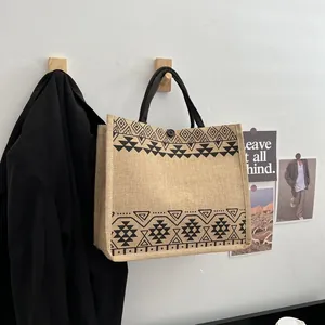 Close-up of ethnic geometric prints and button closure on a jute tote bag