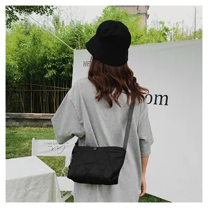Outdoor shot of a black quilted hobo bag styled with a minimalist outfit and casual vibe