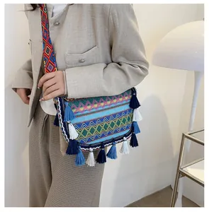 Detailed close-up of bohemian woven crossbody bag with colorful tassels and ethnic patterns