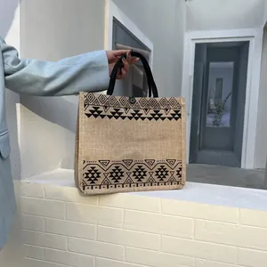 Detail of linen tote bag featuring ethnic geometric patterns and black circular handle