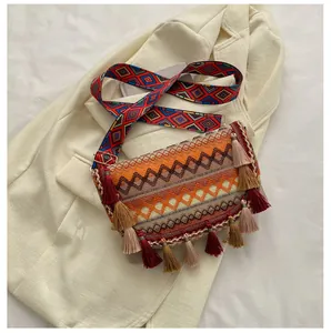 Close-up of bohemian woven bag featuring colorful wave patterns and fringe tassels