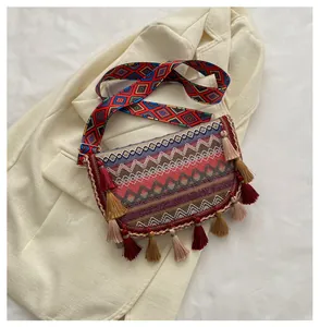 Detailed view of bohemian woven crossbody bag with geometric patterns and fringe tassels