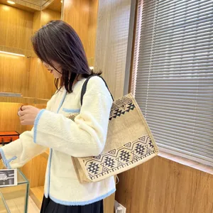 Detail view of ethnic tote bag with geometric print on shoulder of model