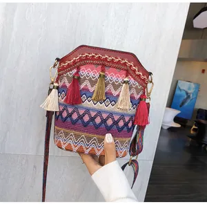 Dettaglio della borsa a secchiello boho con motivi intrecciati colorati e nappe vivaci