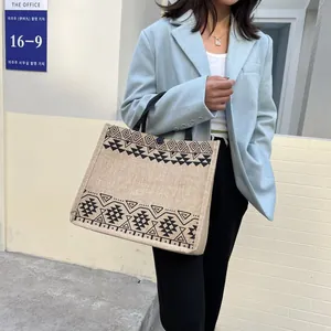 Detail shot of a large jute tote bag with ethnic geometric patterns and black straps