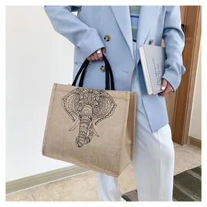 Close-up of vintage elephant print tote bag with woven handles and jute texture