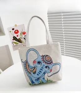 Dettaglio del ricamo di un elefante blu sulla superficie della borsa tote in tela