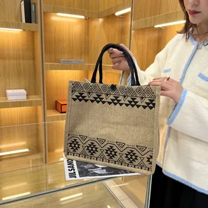 Detail of linen tote bag with geometric tribal patterns and reinforced black canvas handles