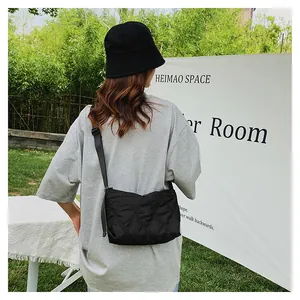 Outdoor lifestyle view of a black quilted crossbody bag with adjustable wide strap
