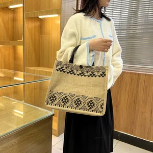 Close-up of linen tote bag with black ethnic geometric patterns and sturdy handles