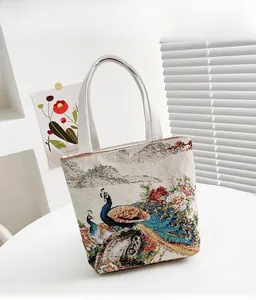 Macro della trama ricamata vintage con pavone su una borsa tote in cotone e lino