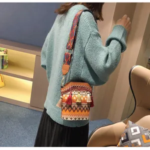 Dettaglio della borsa a secchiello tessuta boho con nappe colorate e tracolla etnica
