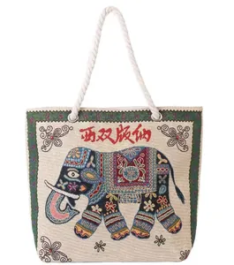 Detail of embroidered elephant pattern and rustic rope handles on canvas tote bag