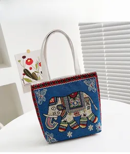 Dettaglio della borsa tote in tela blu con ricamo etnico di elefante e bordo intrecciato