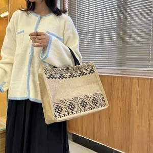 Detail of linen tote bag with ethnic geometric prints and secure button closure