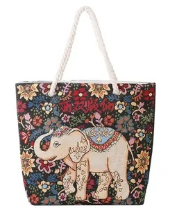 Detail of embroidered elephant canvas tote with floral patterns and rope handles