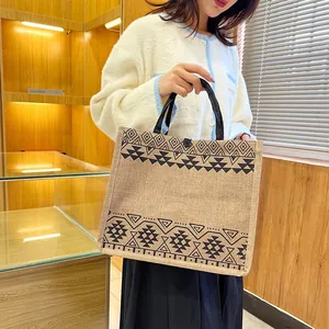 Detailed close-up of a burlap tote bag featuring ethnic geometric patterns and button closure