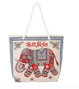 Close-up of ethnic elephant embroidery and red floral pattern on canvas tote bag