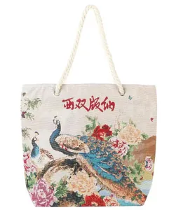 Detailed close-up of ethnic Xishuangbanna tote bag with peacock patterns and cotton rope handle