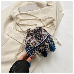 Detail of bohemian drawstring bucket bag with colorful geometric patterns and tassels