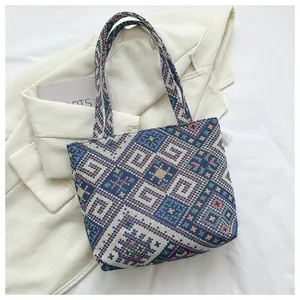 Detail of large woven tote bag with geometric ethnic pattern and stylish long shoulder straps