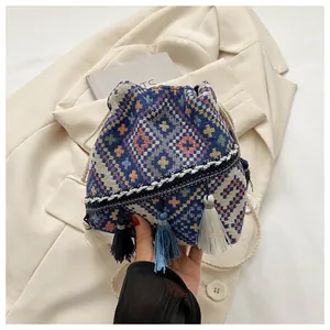 Close-up of ethnic woven bucket bag featuring geometric patterns and colorful tassels