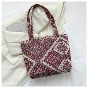 Close-up of geometric jacquard pattern and tassel detail on ethnic style tote bag