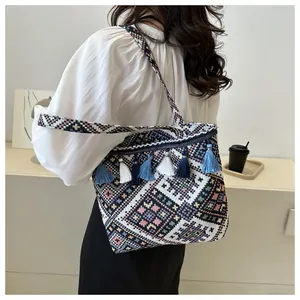 Ethnic bohemian tote bag with colorful tassels and geometric woven patterns on model