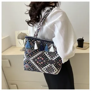 Close-up of geometric woven pattern and colorful tassels on an ethnic tote bag