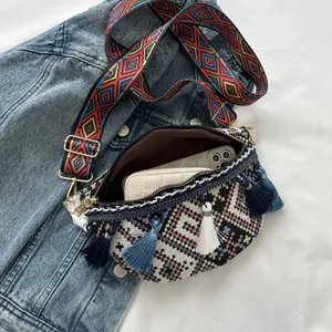 Vue détaillée du sac bohème tissé avec pompons colorés et large bandoulière brodée