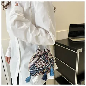 Detailed view of the woven ethnic bucket bag featuring colorful geometric patterns and tassels