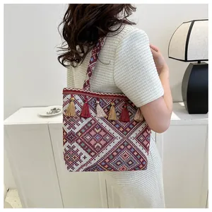 Close-up of ethnic style woven tote bag with colorful tassels and geometric patterns