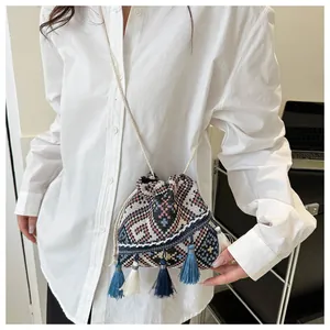 Detail of woven bucket bag featuring geometric patterns and colorful tassel fringes