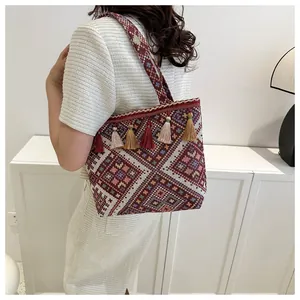 Detail of bohemian woven tote bag with colorful geometric patterns and decorative tassels