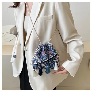 Detailed shot of ethnic woven bucket bag with diamond patterns and colorful tassels
