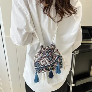Ethnic woven drawstring bucket bag with geometric patterns and colorful tassels