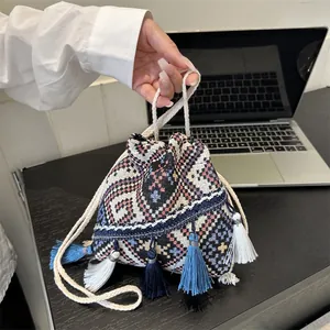Bohemian style woven drawstring bucket bag with colorful geometric patterns and tassels