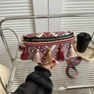 Détail d'un sac bohème tissé avec motifs géométriques colorés et glands en soie