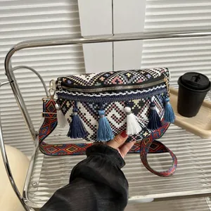 Détail d'un sac de poitrine bohème tissé avec de longues franges et bandoulière ethnique