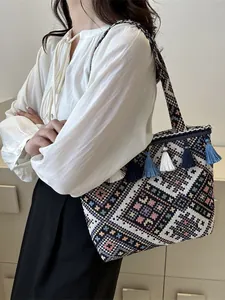Ethnic woven tote bag with geometric patterns, fringe details, and a wide shoulder strap