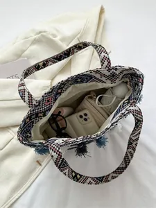 Ethnic woven tote bag with geometric patterns and fringe detail showing large capacity